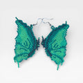 Aretes de chaquira Huichol, alas de mariposa en vibrantes verdes y turquesas.