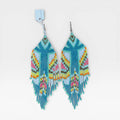 Aretes Huichol de chaquira, azul turquesa, rosa y amarillo con patrón geométrico.