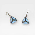 Aretes Huichol de chaquira triangulares celestes y tornasol con diseño geométrico.