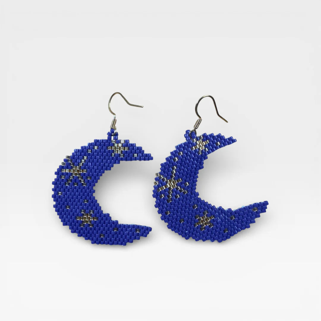 Aretes luna creciente de chaquira azul y plata con diseño de estrellas.