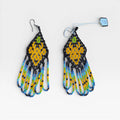 Aretes de chaquira negros, amarillos y turquesa: patrón floral con flecos largos.