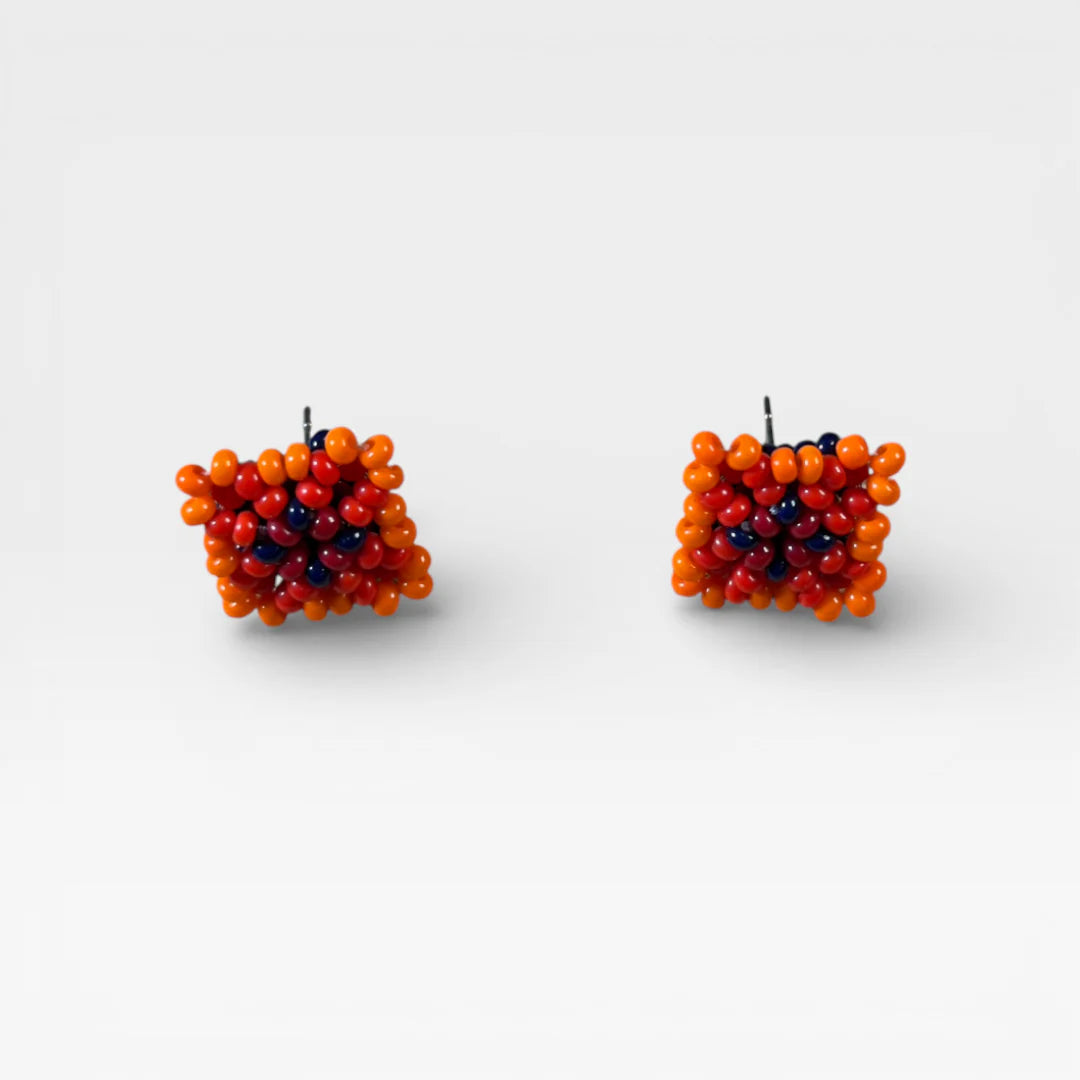 Aretes Wixárika de chaquira cuadrados, naranja, rojo y azul oscuro, diseño geométrico.