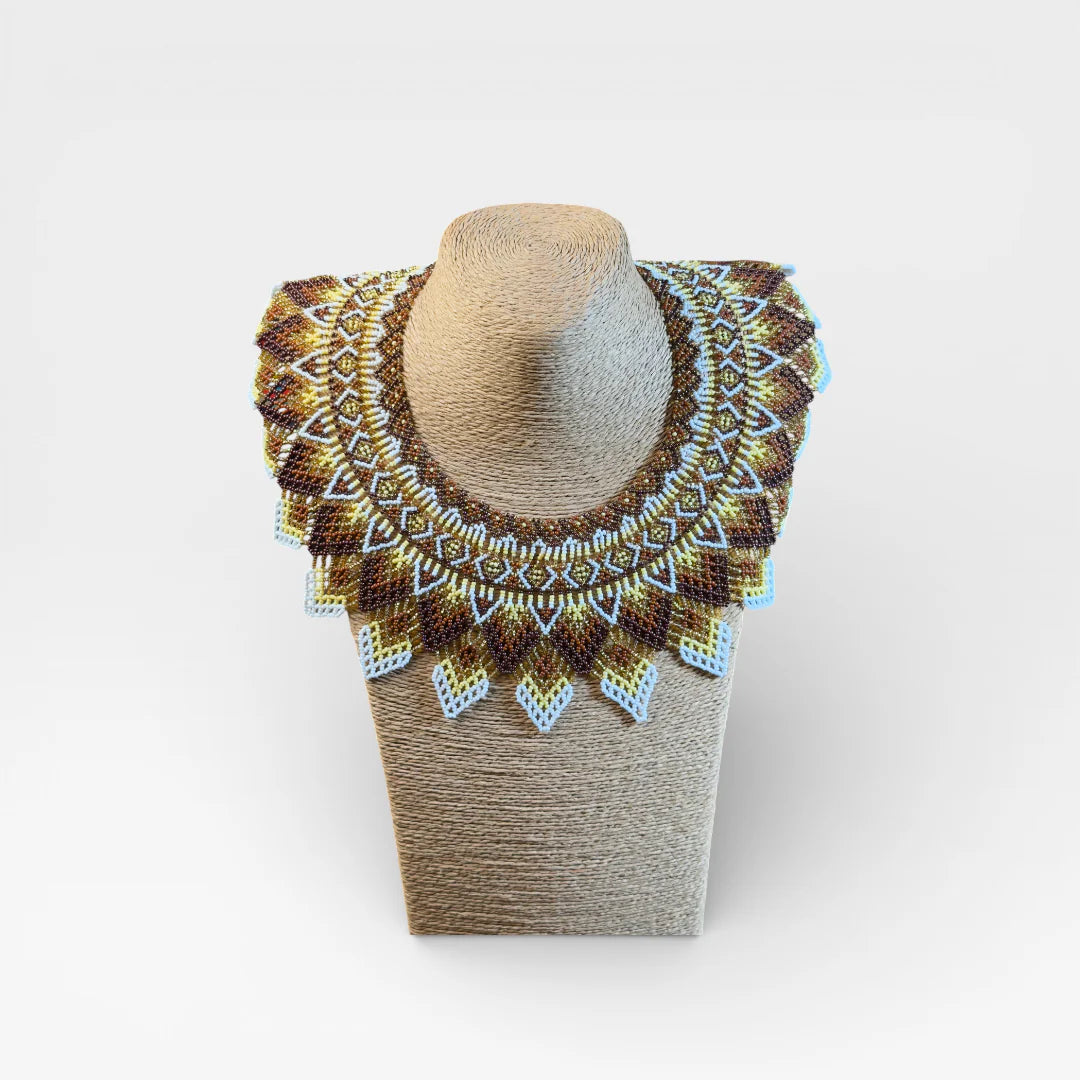 Collares Wixárika de chaquira, diseño concéntrico geométrico en marrón, dorado y blanco.