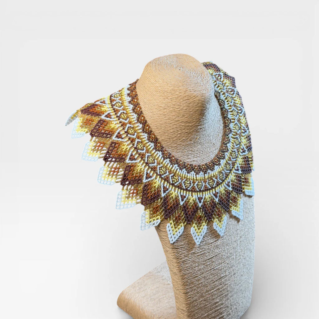 Collares Wixárika de chaquira, diseño concéntrico geométrico en marrón, dorado y blanco.