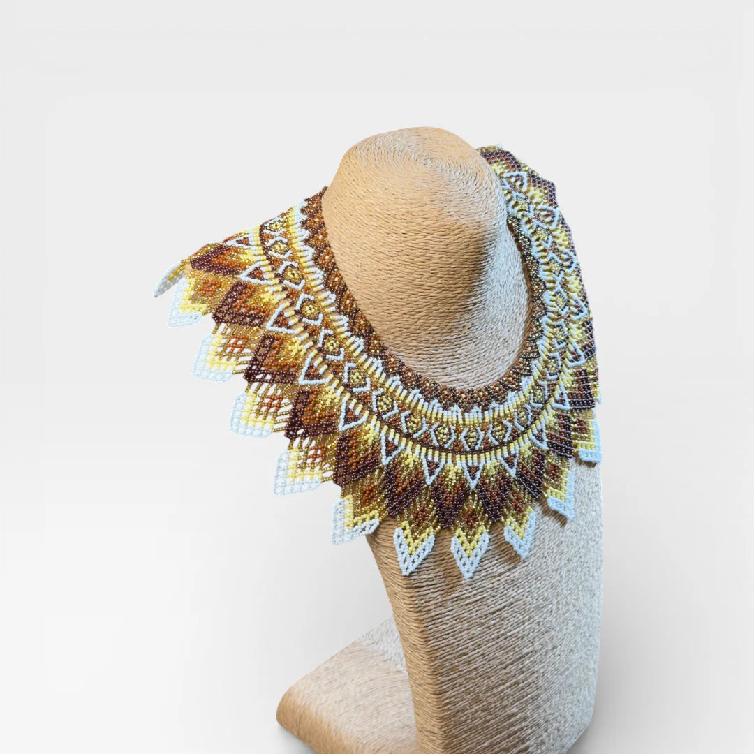 Collares Wixárika de chaquira, diseño concéntrico geométrico en marrón, dorado y blanco.