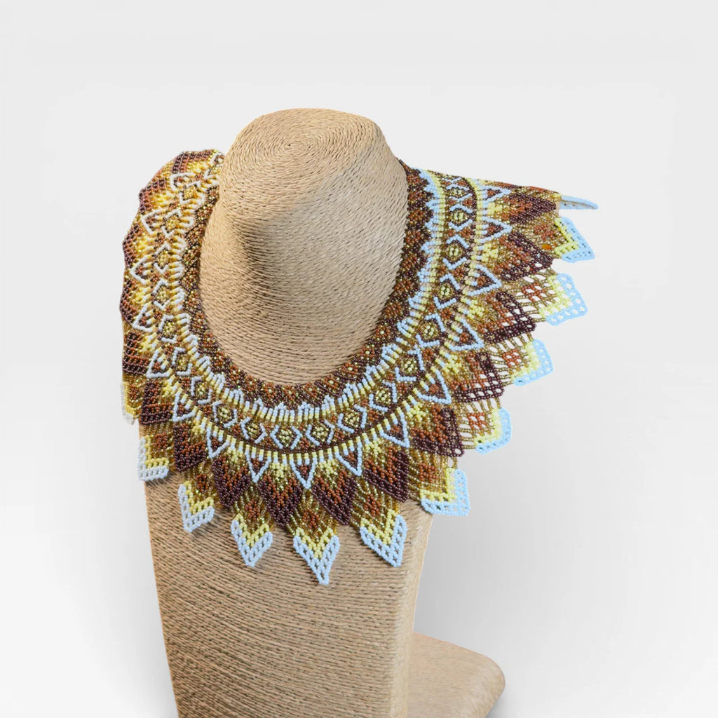 Collares Wixárika de chaquira, diseño concéntrico geométrico en marrón, dorado y blanco.