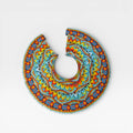 Collar Huichol con chaquira, diseño geométrico radial en azul, amarillo y naranja.