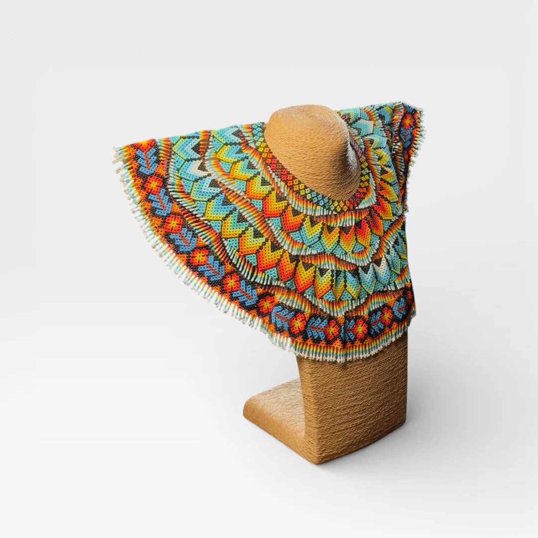 Collar Huichol con chaquira, diseño geométrico radial en azul, amarillo y naranja.