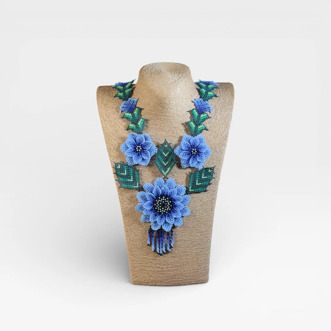 Collares: Chaquira Wixárika floral con flores azules y follaje verde vibrante.
