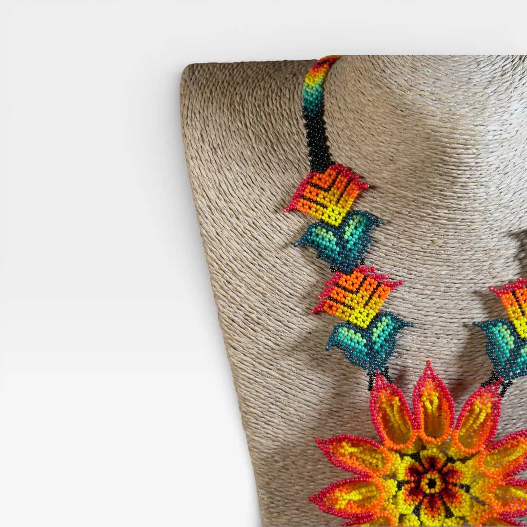 Collares: Collar Huichol de chaquira, flor central amarilla y naranja con detalles turquesa.