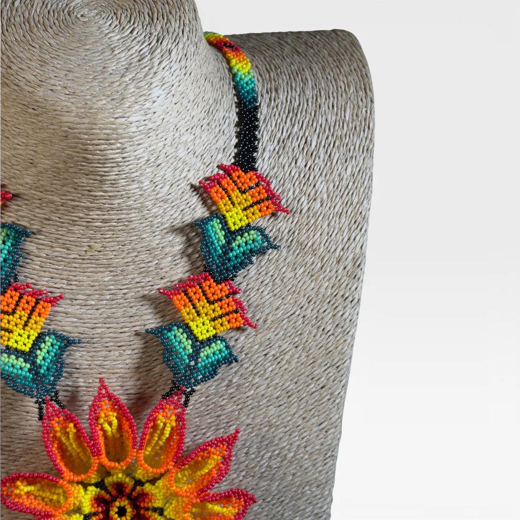 Collares: Collar Huichol de chaquira, flor central amarilla y naranja con detalles turquesa.