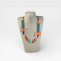 Collar Huichol de chaquira, mariposas naranja, patrón zigzag verde y detalles amarillos.