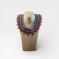Collar de chaquira Huichol azul, naranja y amarillo con diseño tradicional de rombos.
