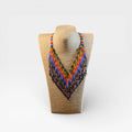 Collar Huichol de chaquira, patrón zig-zag en azul, rojo y amarillo.