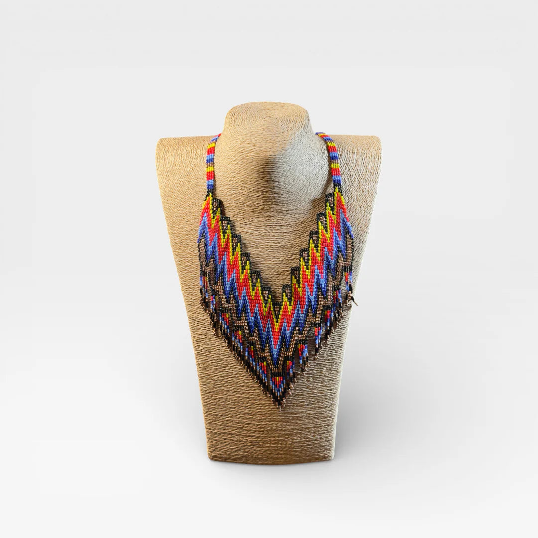 Collar Huichol de chaquira, patrón zig-zag en azul, rojo y amarillo.