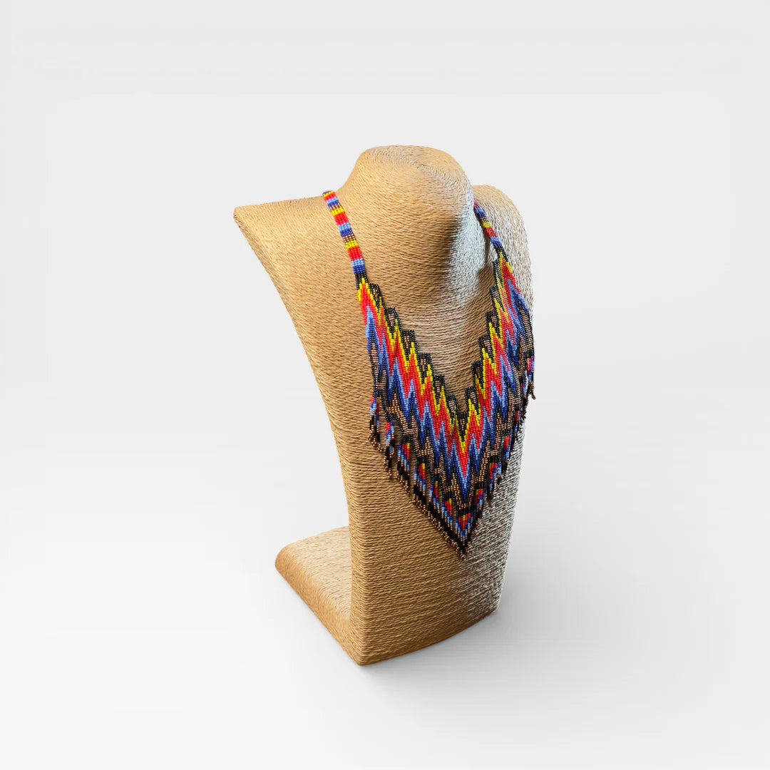 Collar Huichol de chaquira, patrón zig-zag en azul, rojo y amarillo.