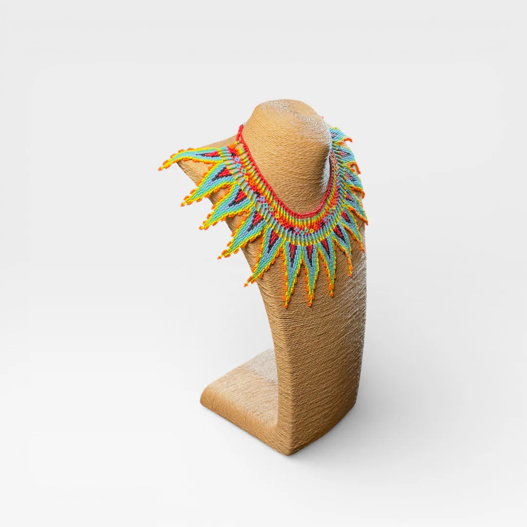 Collares: Collar Huichol de chaquira, diseño de rayos en azul, naranja y amarillo.