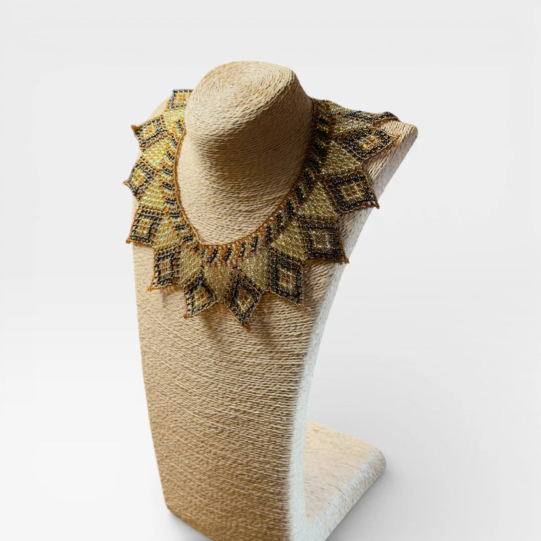 Collar de chaquira Huichol dorado, negro y café con patrón de rombos y puntas.