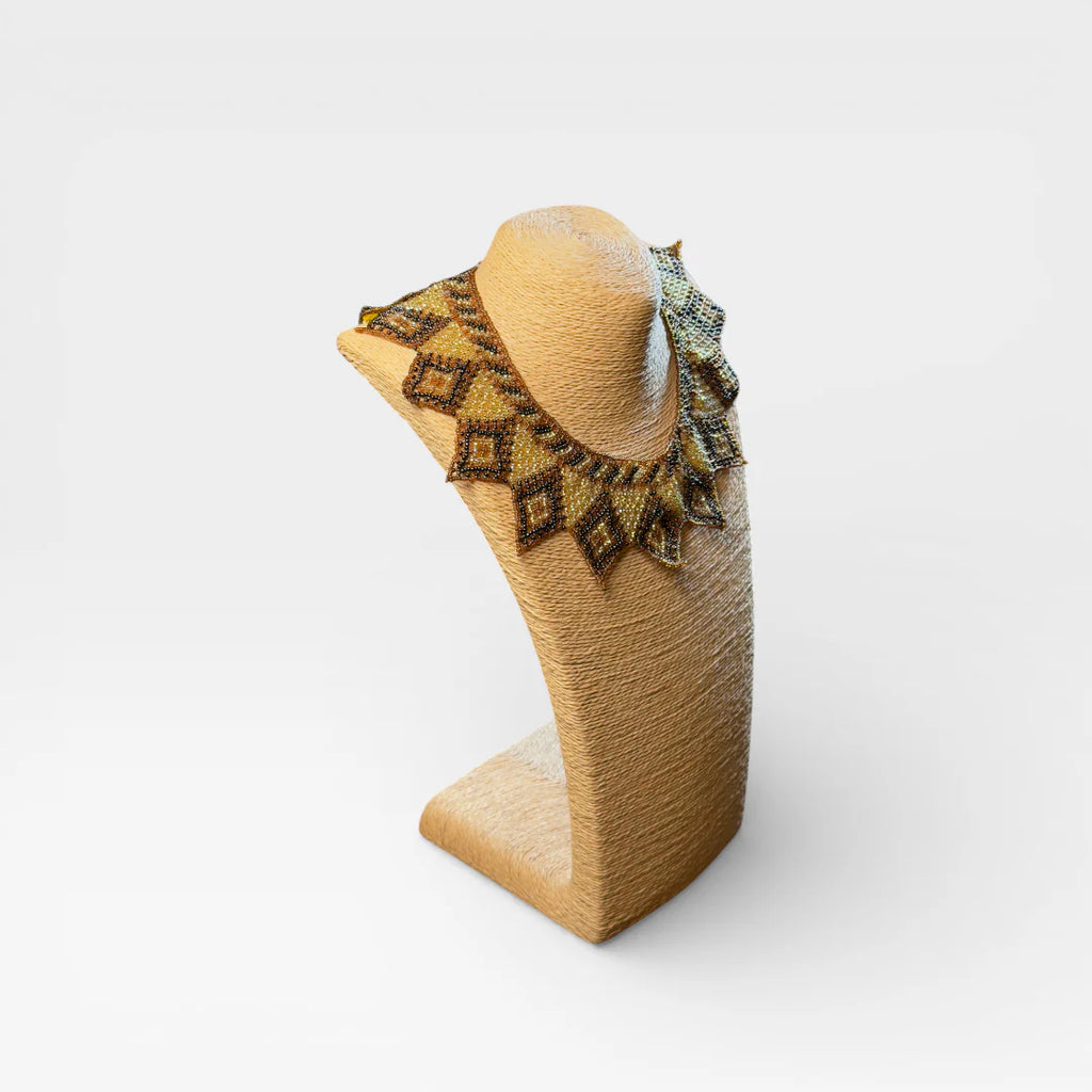 Collar de chaquira Huichol dorado, negro y café con patrón de rombos y puntas.