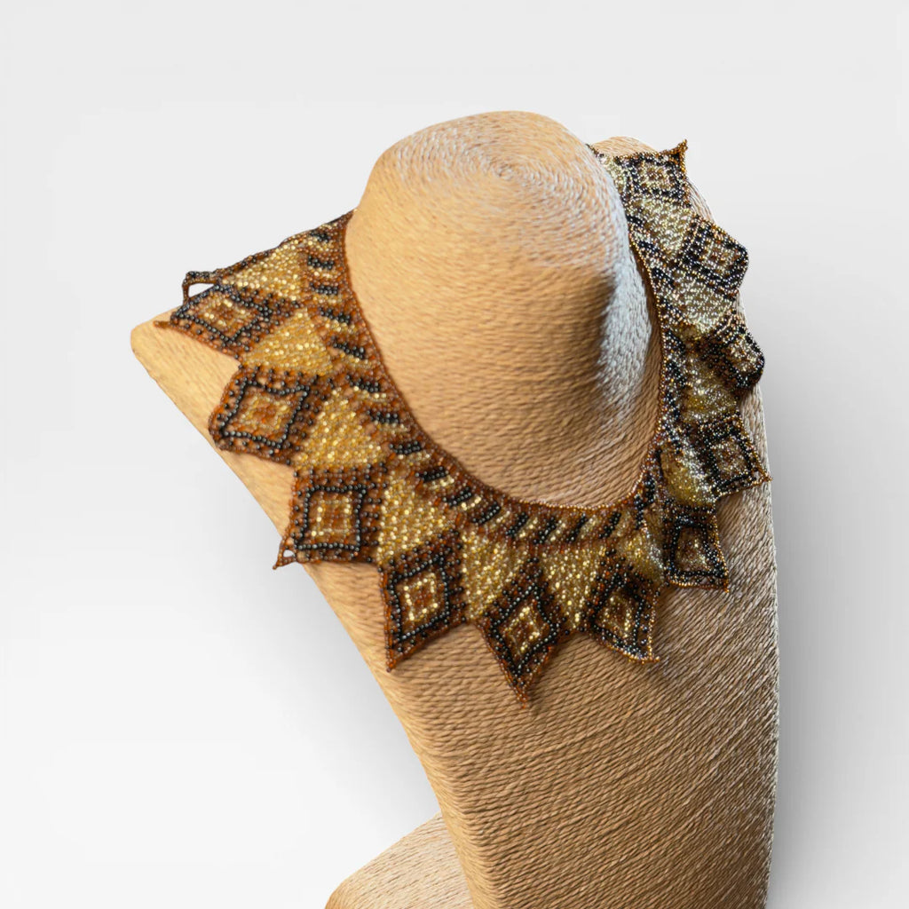 Collar de chaquira Huichol dorado, negro y café con patrón de rombos y puntas.