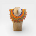 Collar Huichol de chaquira naranja, amarillo y azul con patrón de rombos geométricos.