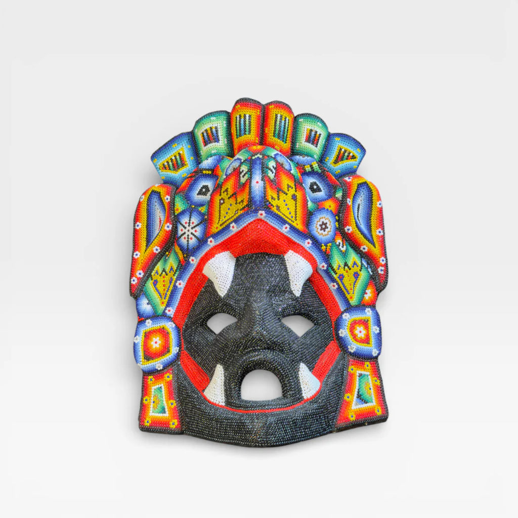 Figuras de Chaquira: Máscara Huichol con colmillos, rostro negro, boca roja y diseños vibrantes.
