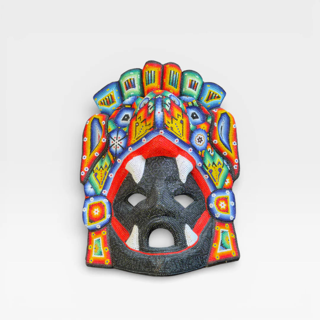 Figuras de Chaquira: Máscara Huichol con colmillos, rostro negro, boca roja y diseños vibrantes.