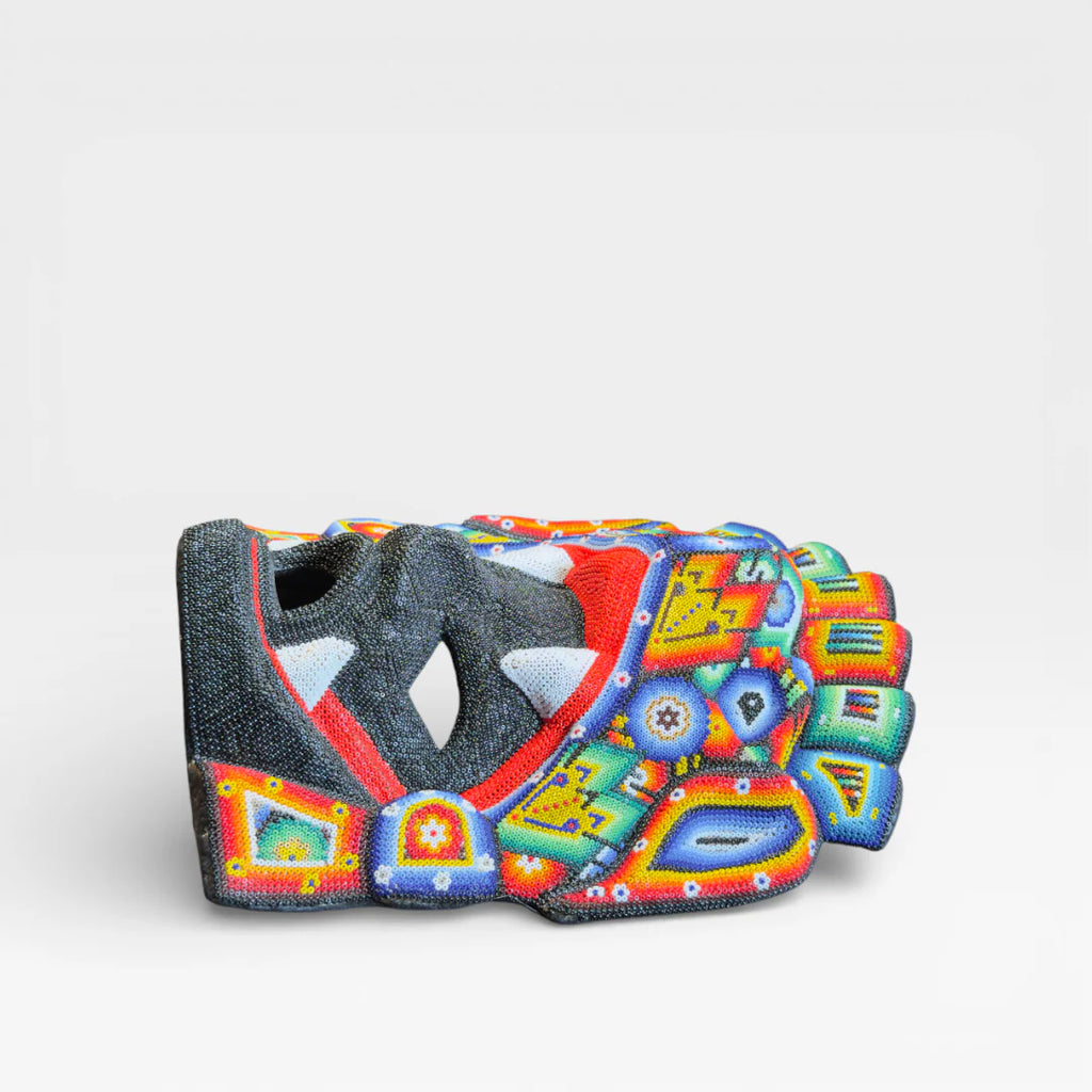 Figuras de Chaquira: Máscara Huichol con colmillos, rostro negro, boca roja y diseños vibrantes.