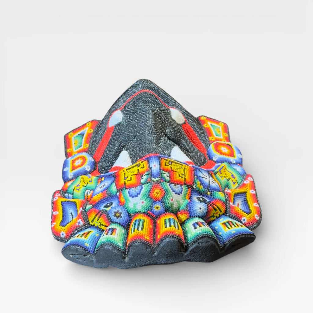 Figuras de Chaquira: Máscara Huichol con colmillos, rostro negro, boca roja y diseños vibrantes.