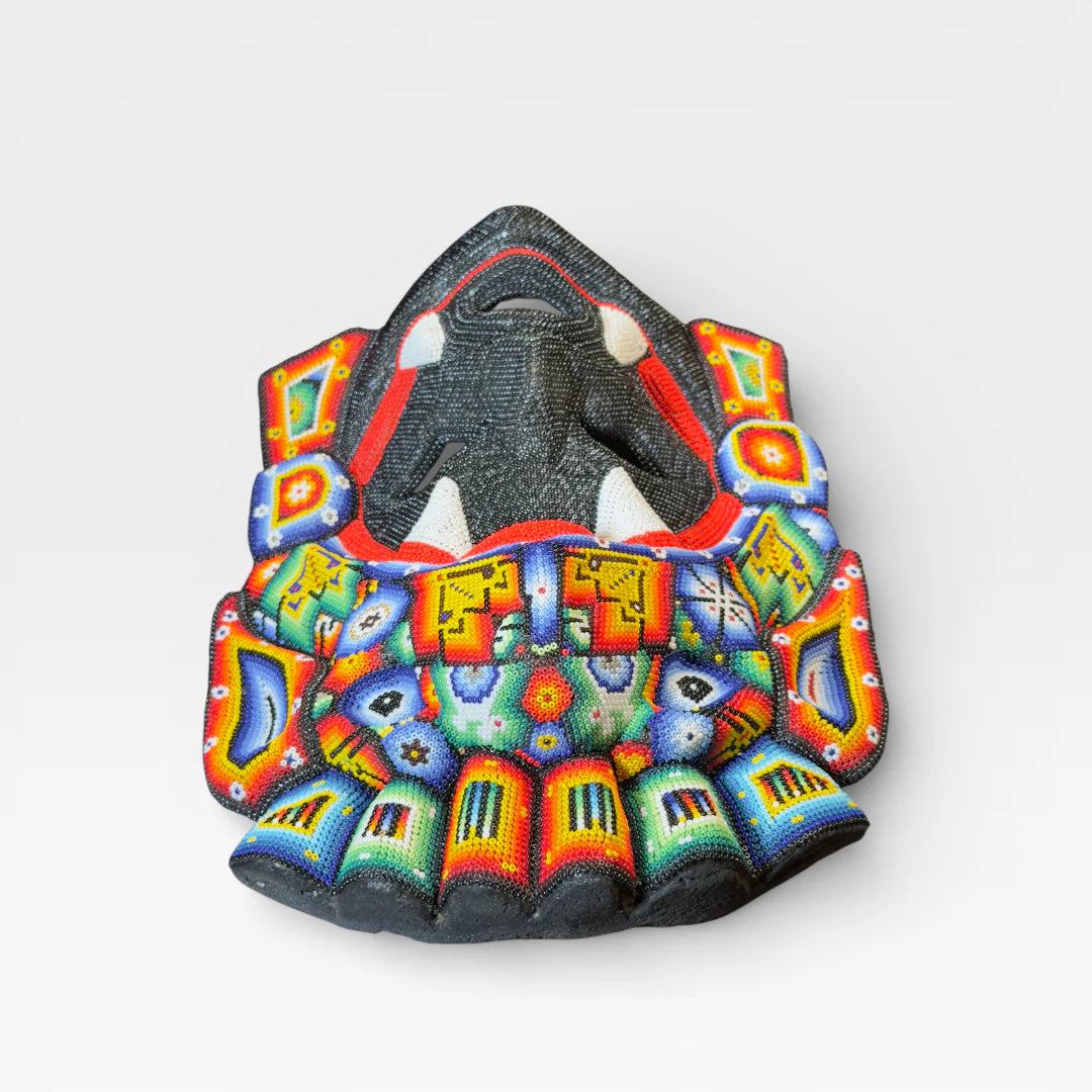 Figuras de Chaquira: Máscara Huichol con colmillos, rostro negro, boca roja y diseños vibrantes.