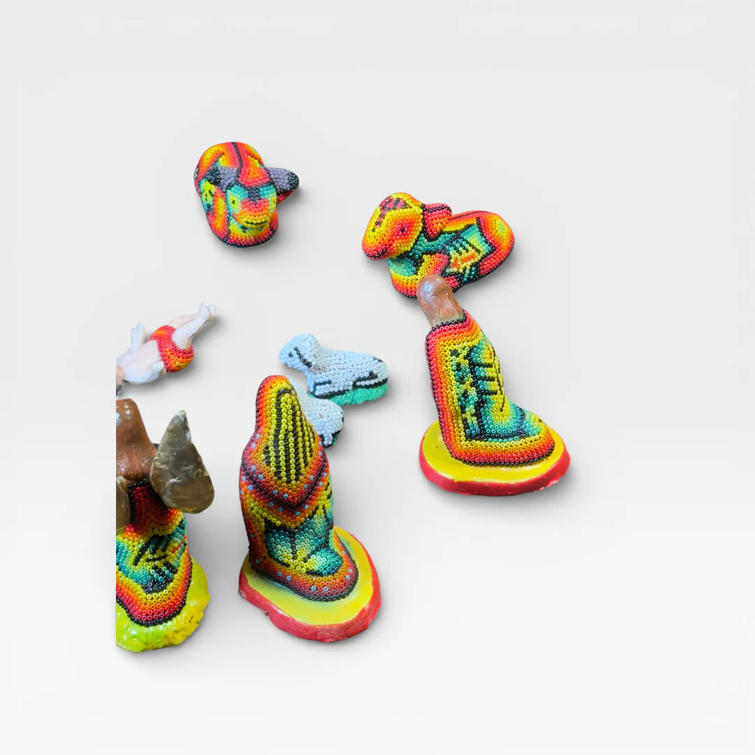 Figuras de Chaquira Huichol, vibrantes amarillo, azul y rojo con patrones geométricos tradicionales.
