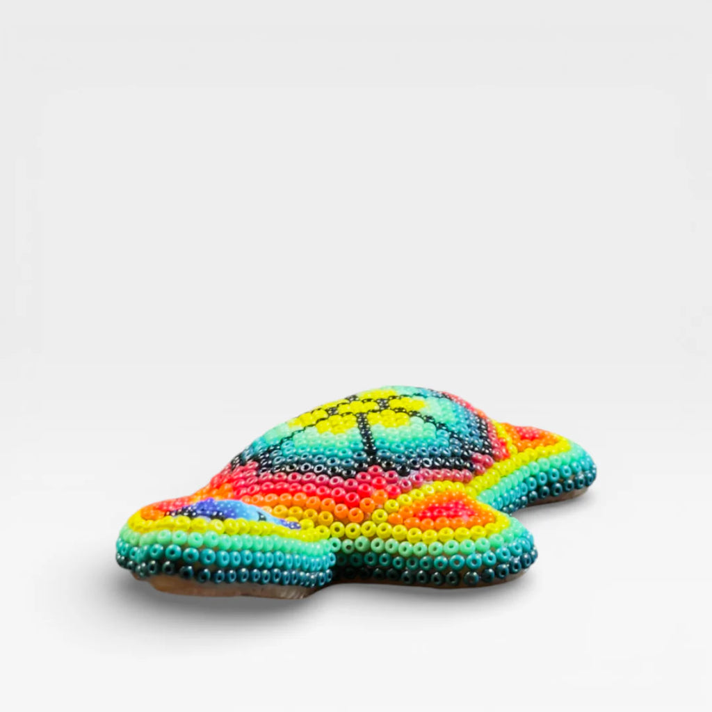 Figura de Chaquira Huichol: Tortuga azul, verde y naranja con diseño geométrico.
