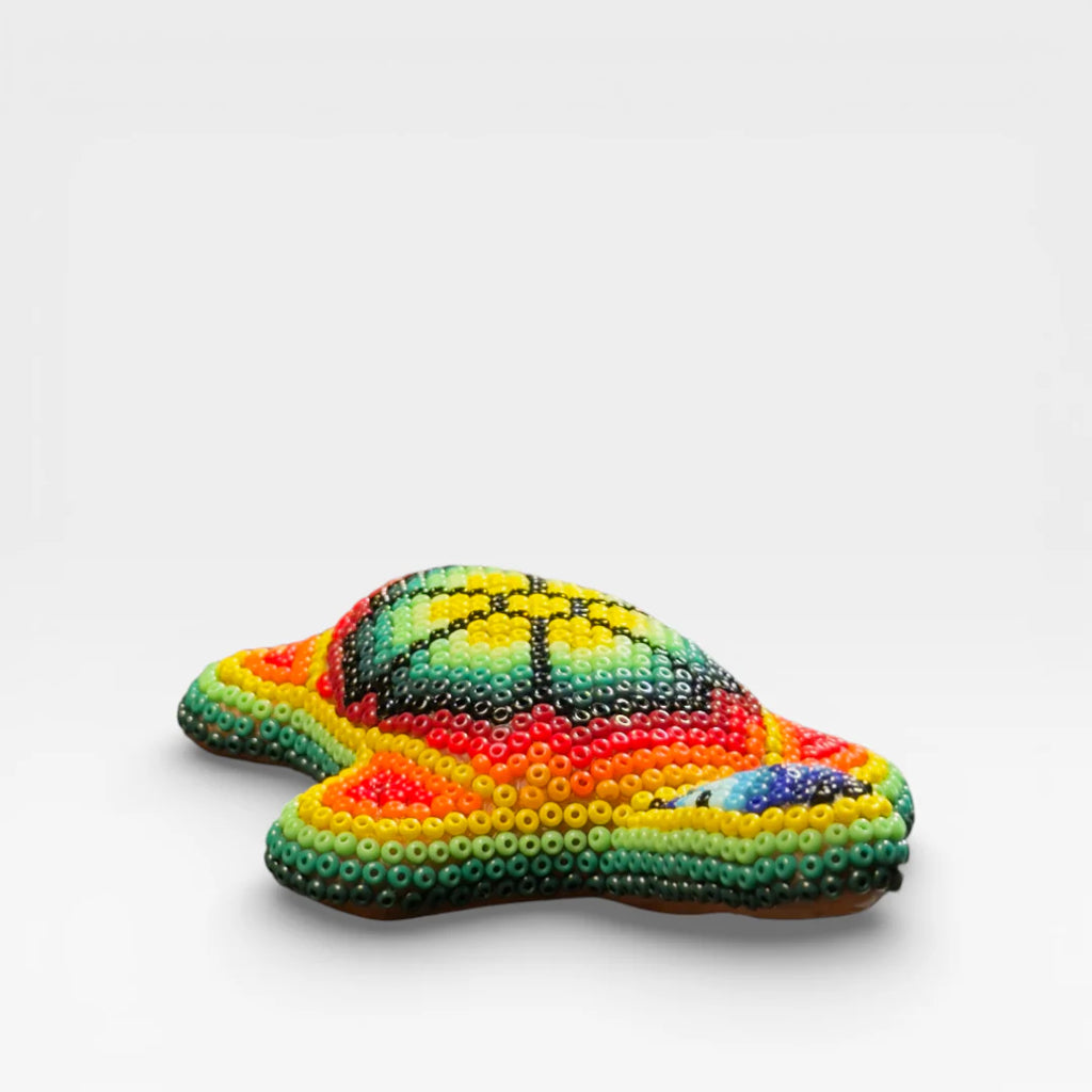 Figura de Chaquira Huichol: Tortuga azul, verde y naranja con diseño geométrico.
